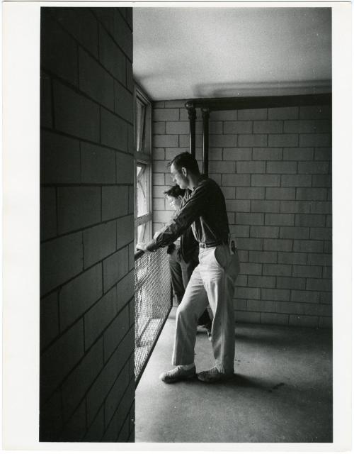 Father and boy with glasses looking out window, from the series Big Brother