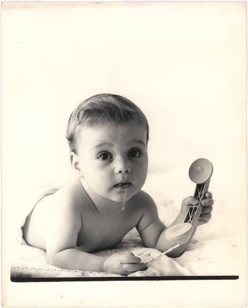 Portrait of drooling baby with toy telephone