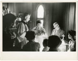 Priest and family at baptism ceremony