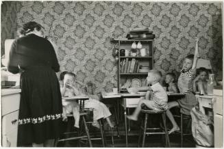 Mother watching children at table